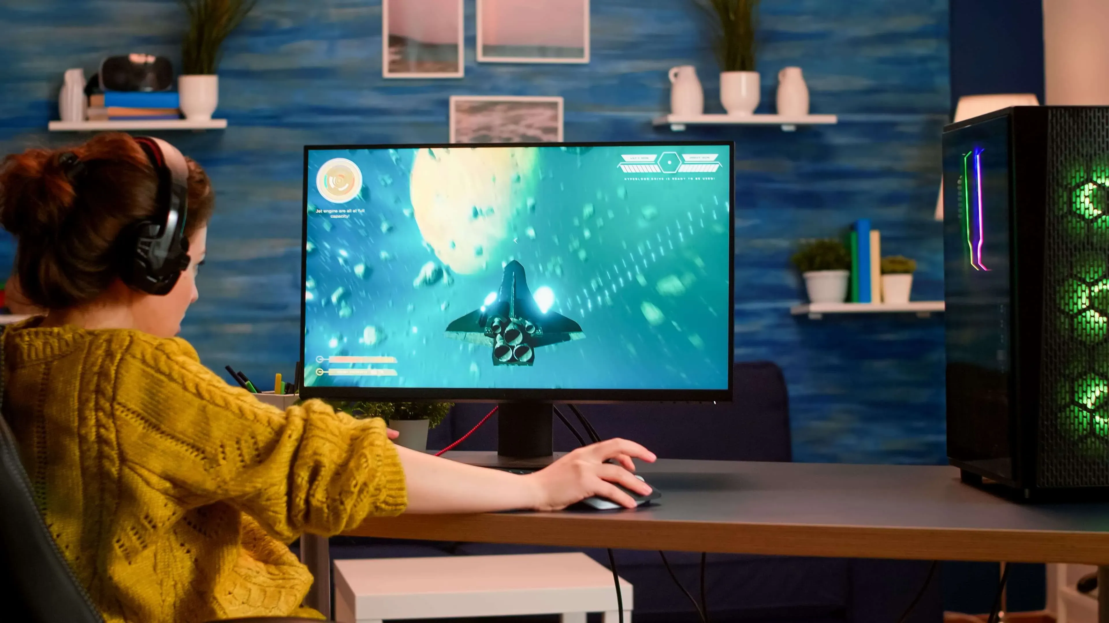 Child wearing headphones plays a space game on a desktop computer at home.