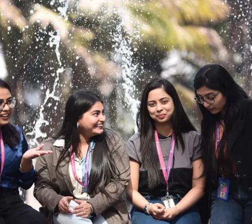 Group of TP employees talking and smiling near a fountain outdoors