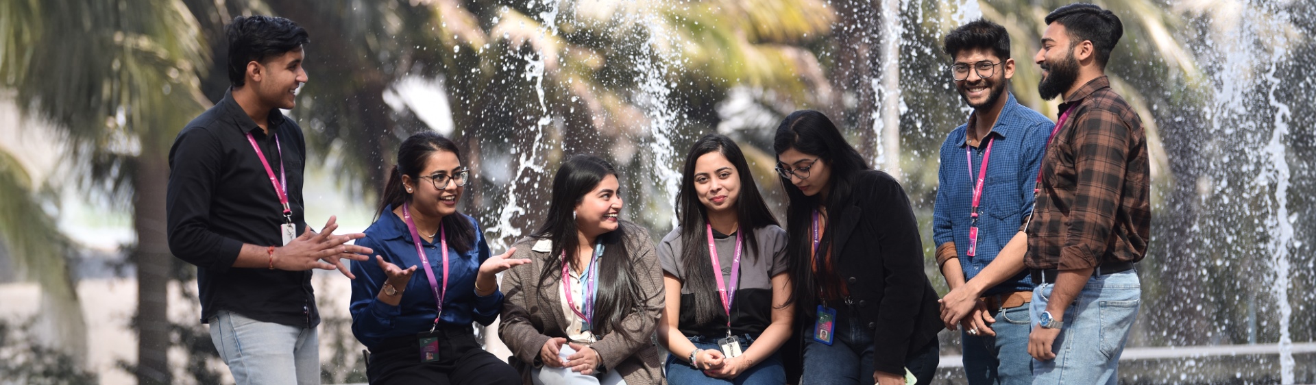 Group of TP employees talking and smiling near a fountain outdoors