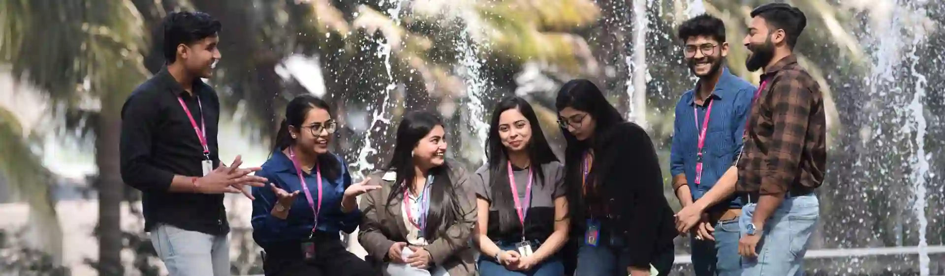 Group of TP employees talking and smiling near a fountain outdoors