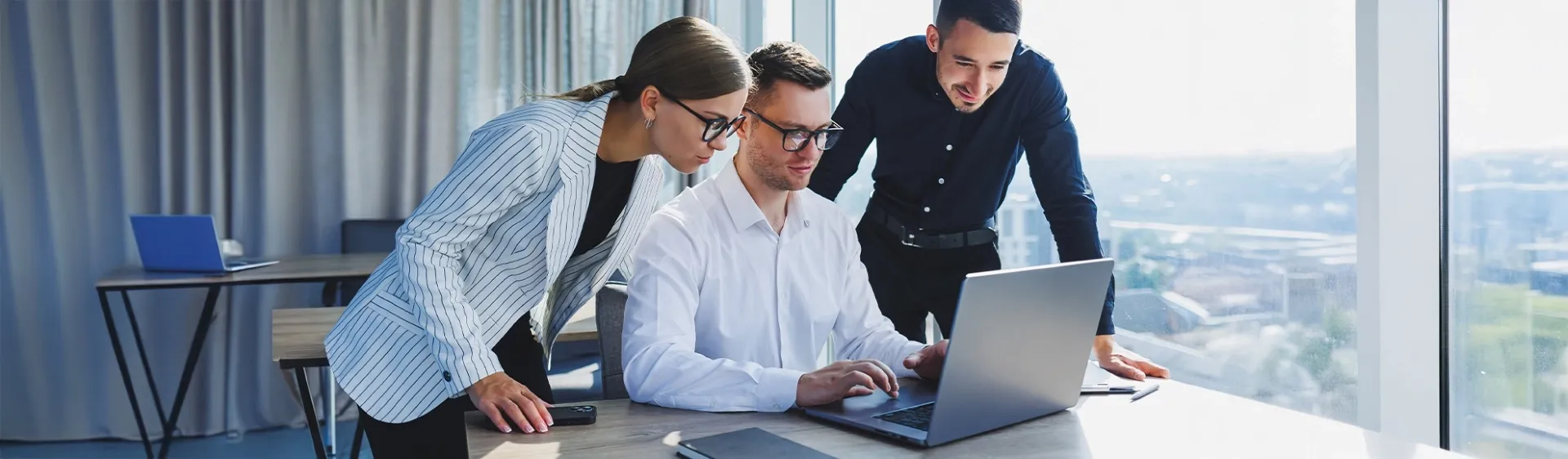 Business team collaborating on a laptop, illustrating TP’s insights on five key industry trends in ANZ claims services.