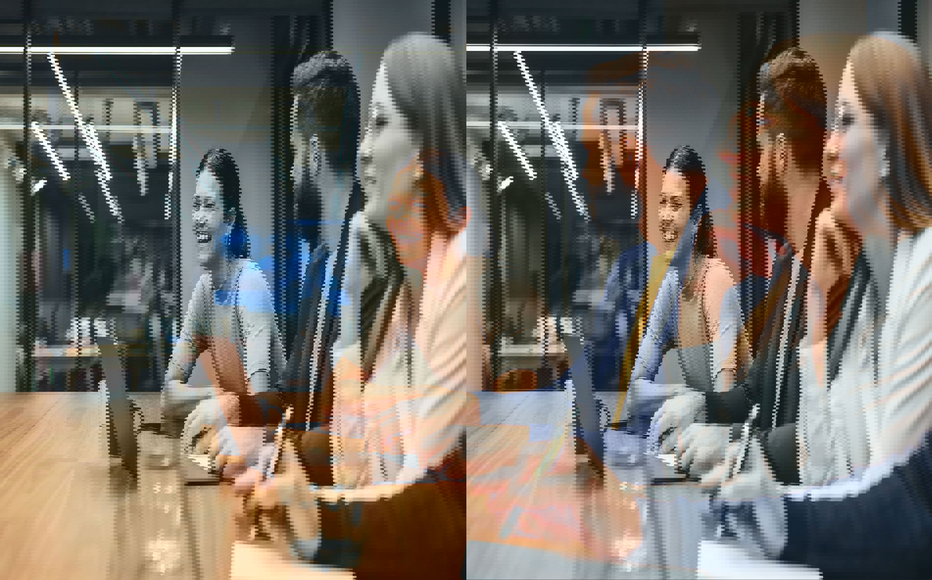 TP team members smiling and collaborating during a meeting.