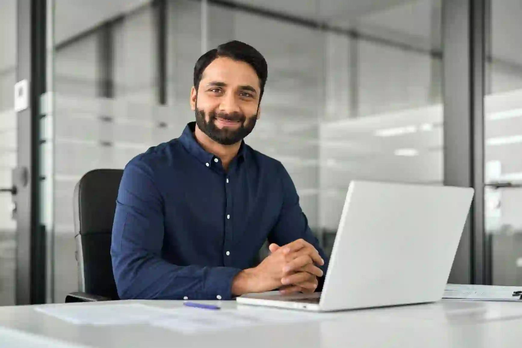 Business man working on his notebook and smiling at the camera