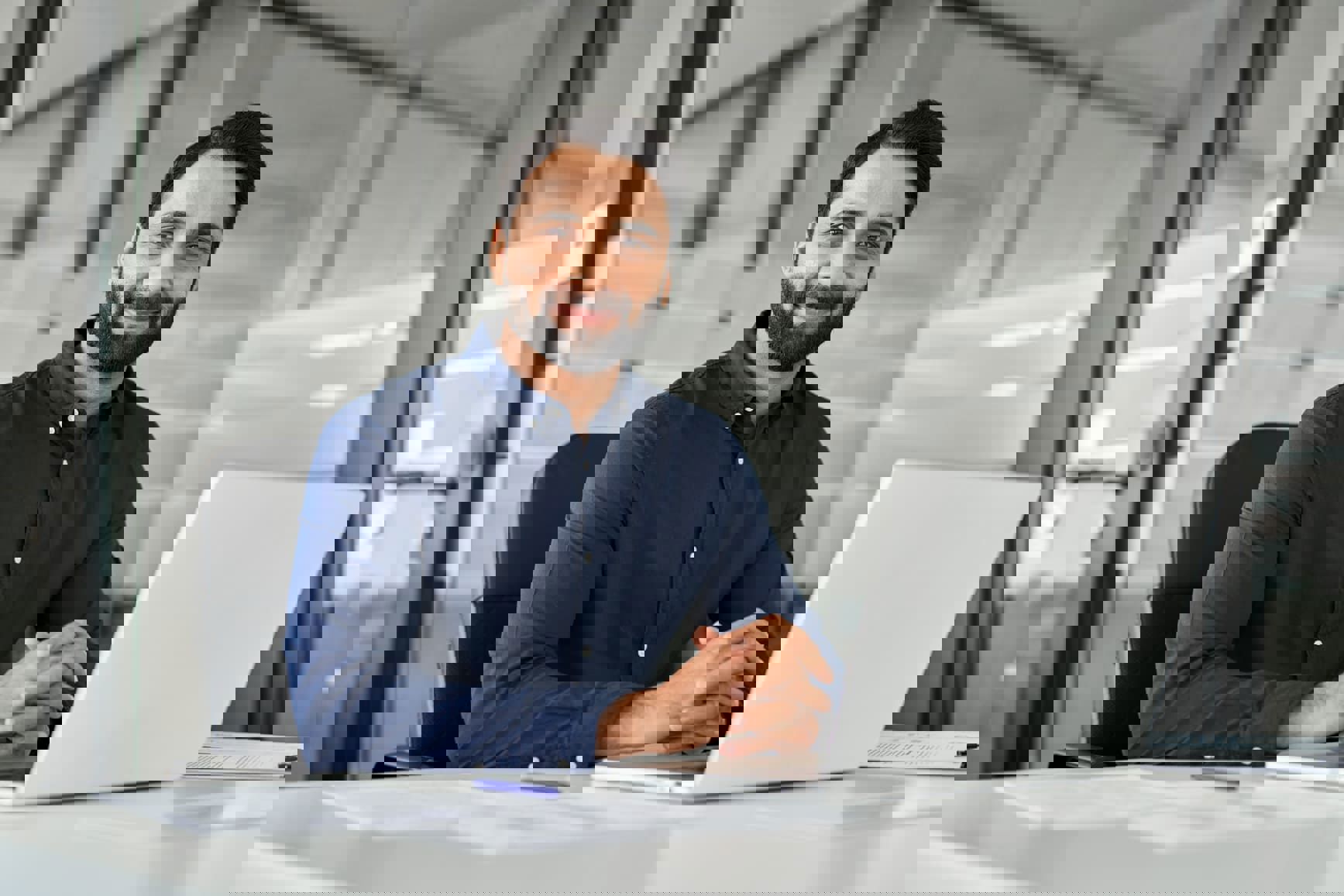 Business man working on his notebook and smiling at the camera