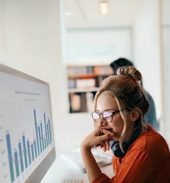 Professional analyzing data charts on a digital screen, illustrating advanced analytics insights.