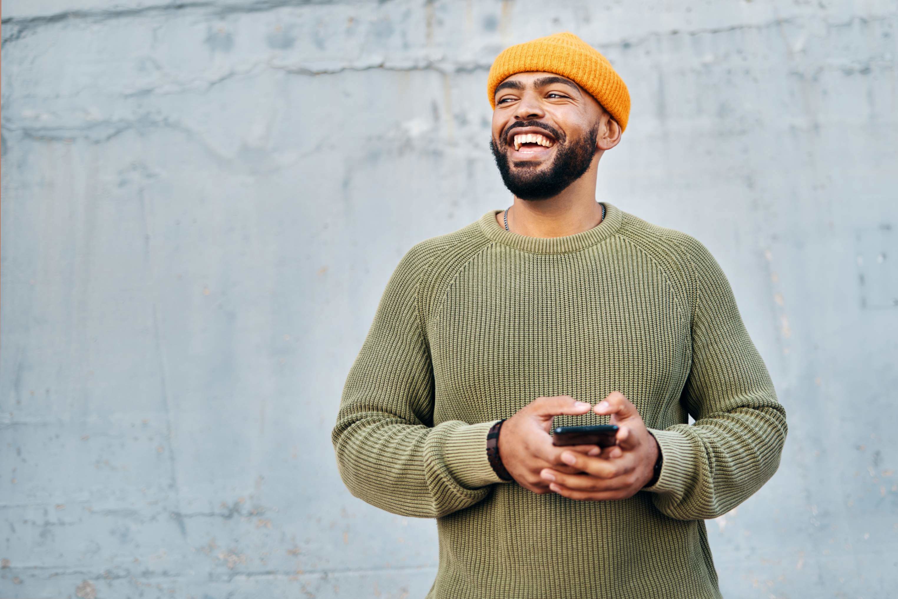 Smiling man in a beanie holding a phone, representing TP’s focus on connection and positive experiences. Smiling man in a beanie holding a phone, representing TP’s focus on connection and positive experiences.