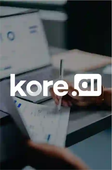 kore.ai logo in focus and a person writing on a paper in the background