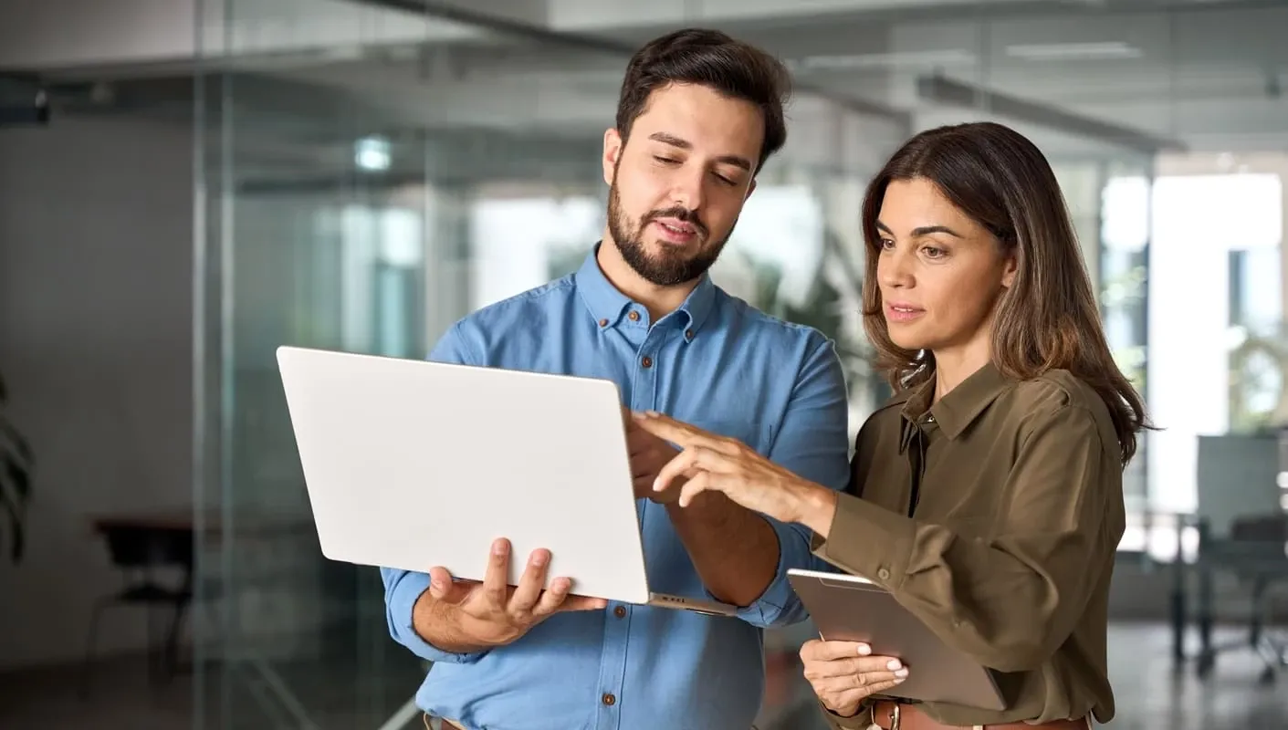 Entrepreneurial couple collaborating on a laptop in a modern office, illustrating Revenue as a Service solutions and scalable B2B sales growth.