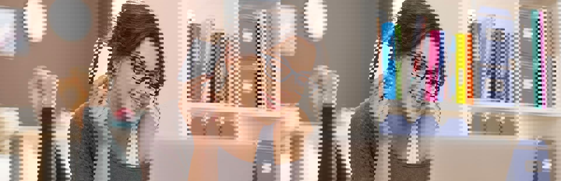 Smiling woman holding her credit card while shopping online from home