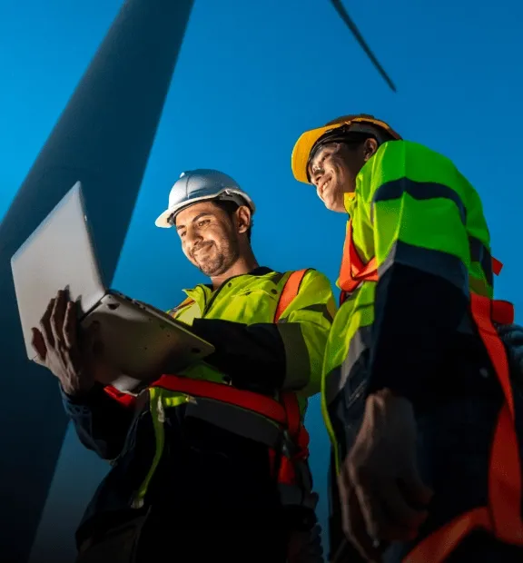 Wind power tower operators working on computer