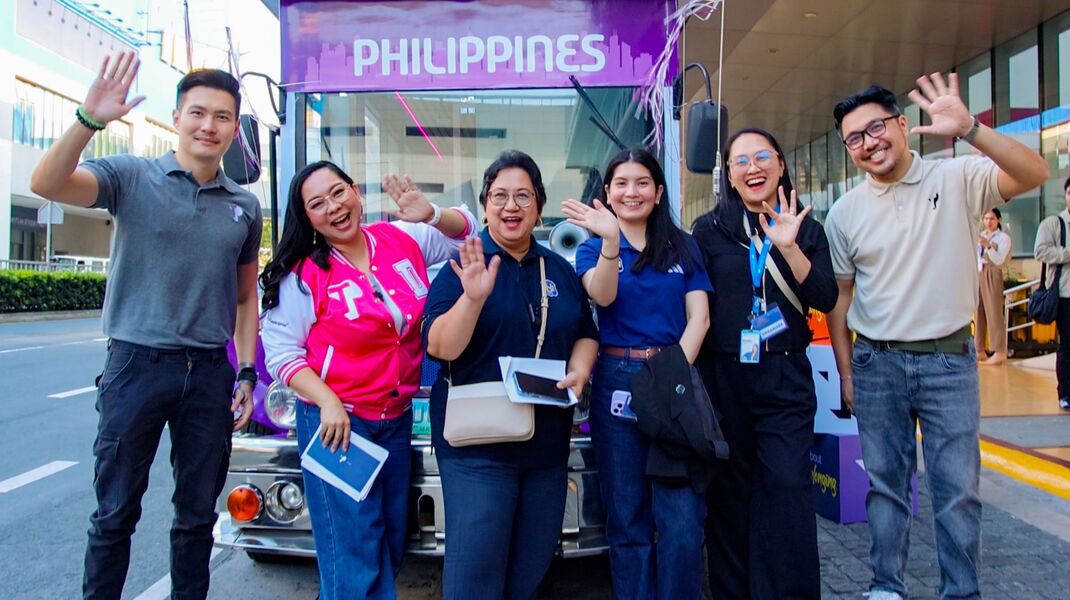 3 smiling TP employees with 3 National University representatives in front of the TP Jeepney