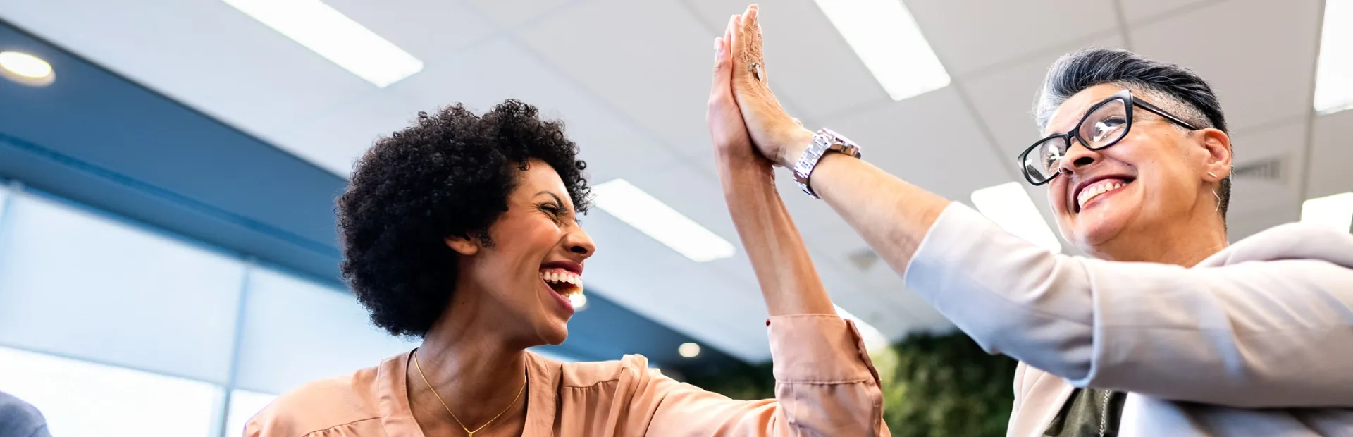 Two colleagues celebrating a team achievement in the office.