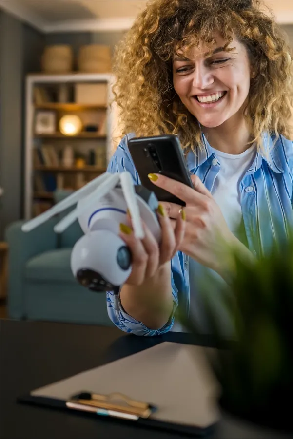 Smiling girl holding a smartphone in a casual setting.