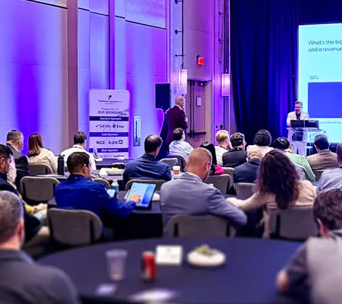Attendees listen to a business presentation at a conference.