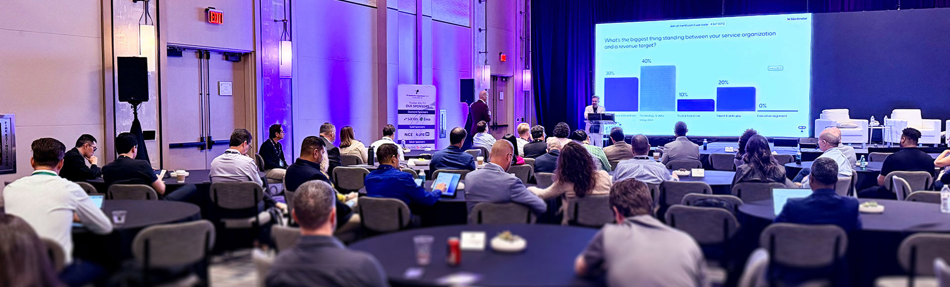 Attendees listen to a business presentation at a conference.