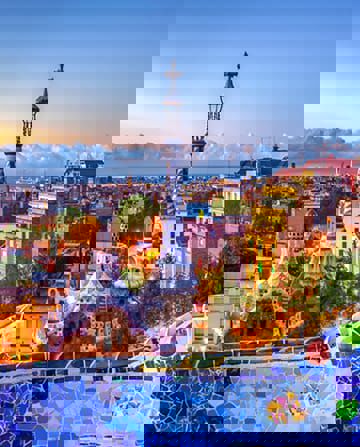 Vista de Barcelona con el monumento a Colón y los coloridos mosaicos de Gaudí en primer plano.