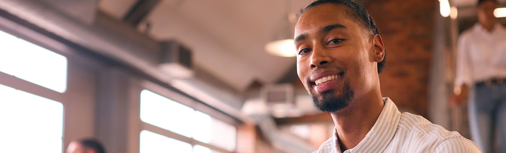 Smiling young man celebrating TP’s recognition as a Leader in Everest Group’s CXM Services 2025.