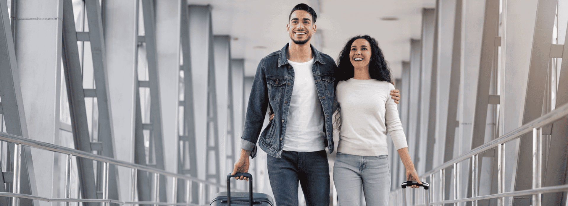 Smiling couple walking with luggage at an airport, symbolizing safe and stress-free travel. Smiling couple walking with luggage at an airport, symbolizing safe and stress-free travel.