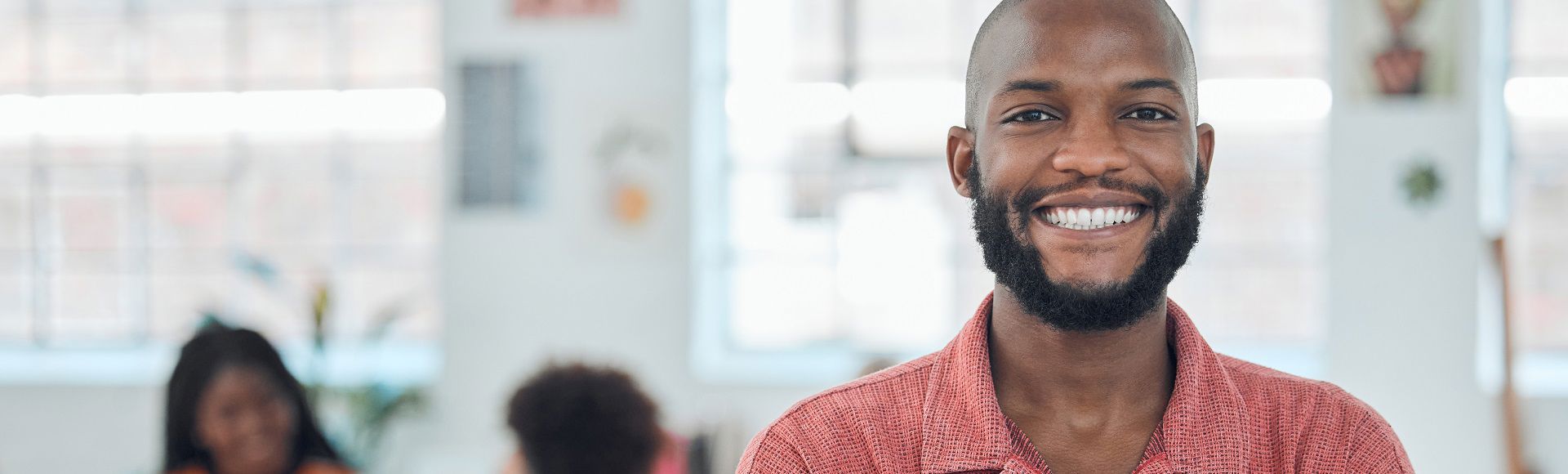 Smiling young African man, illustrating article on safeguarding Azure VMs with robust backups for security. Smiling young African man, illustrating article on safeguarding Azure VMs with robust backups for security.
