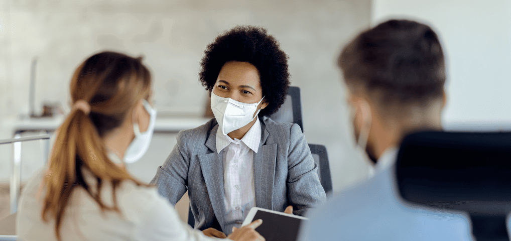 People carrying a conversation using masks