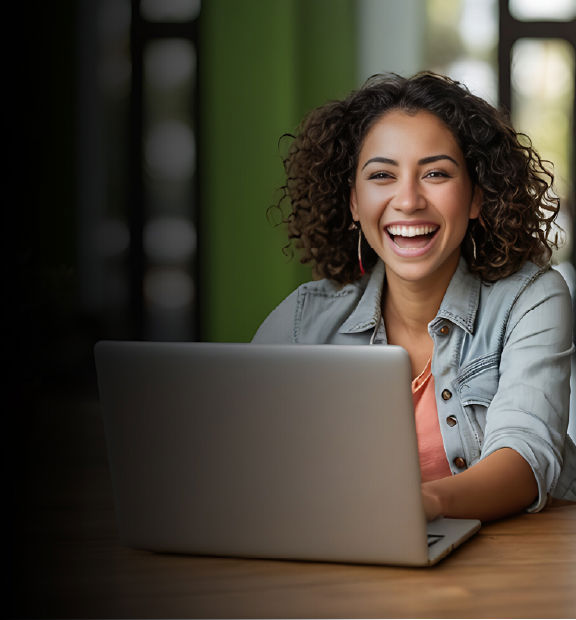 Smiling Latin woman using a laptop in a professional setting.