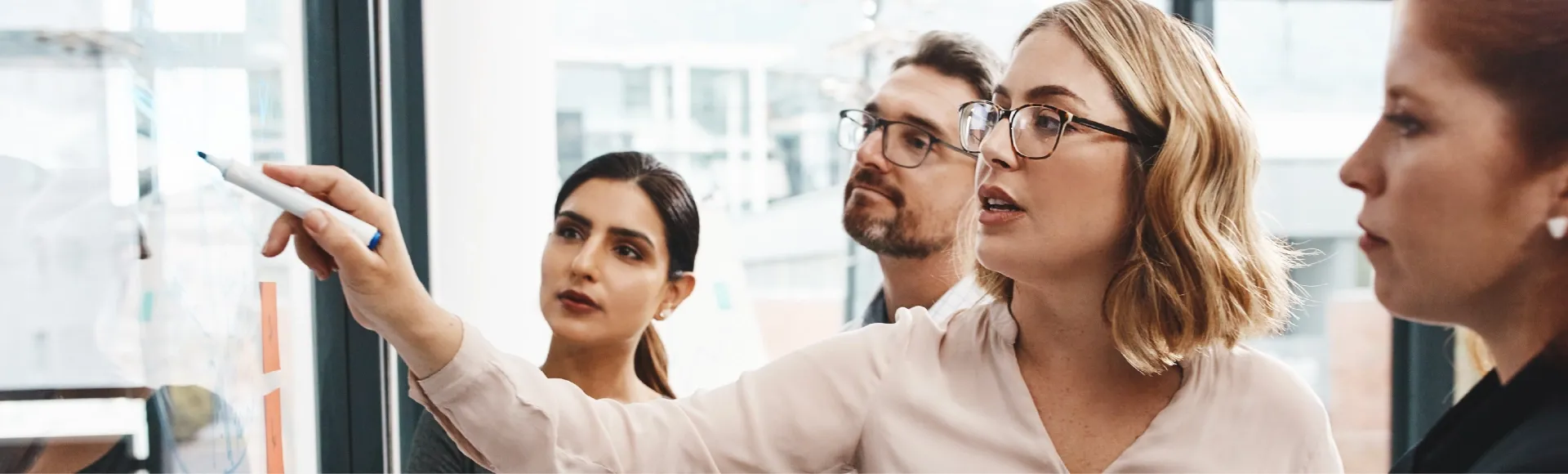 Professionals planning business strategies on a writable wall.