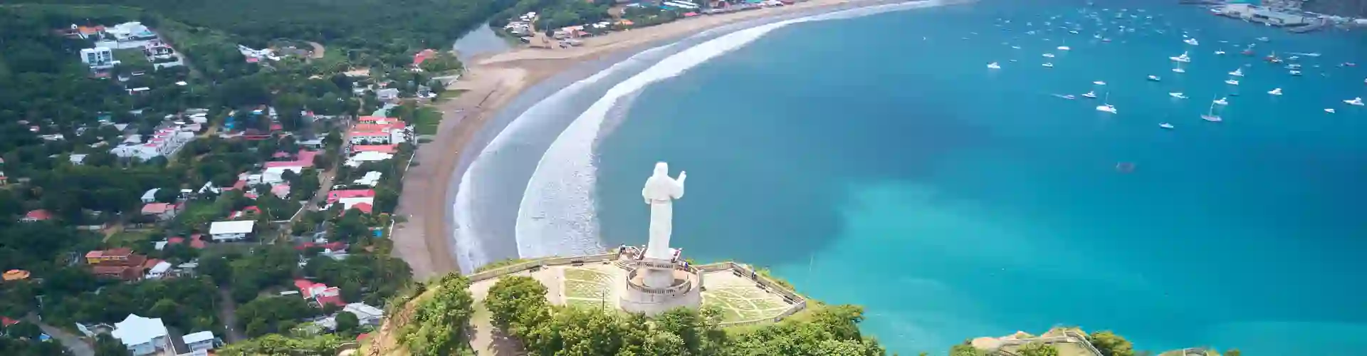 TP in Nicaragua - city view showing a statue in the foreground and a coastal city with crystal clear waters in the background