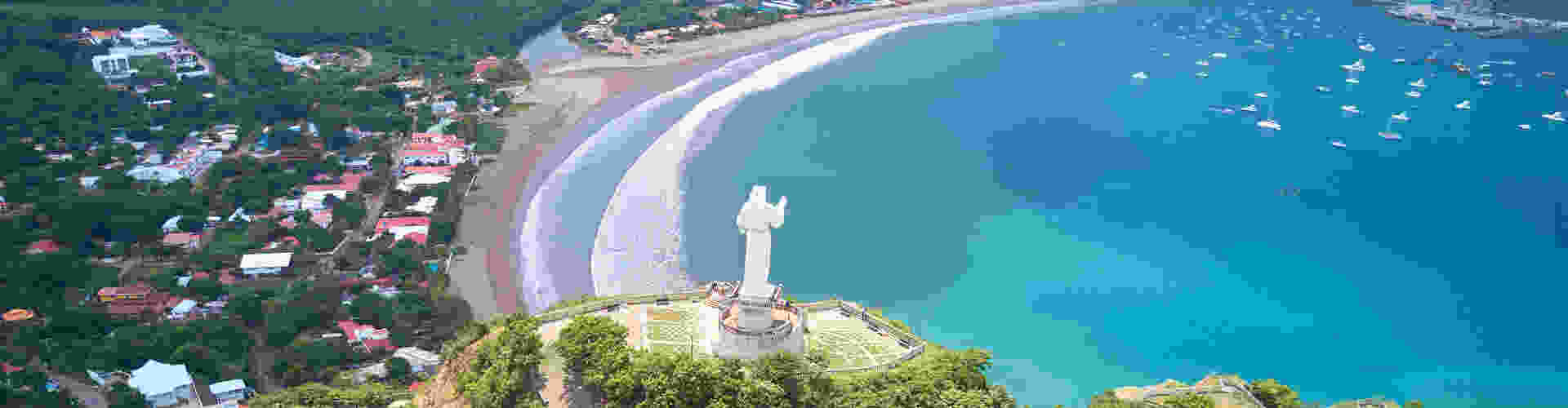 TP in Nicaragua - city view showing a statue in the foreground and a coastal city with crystal clear waters in the background