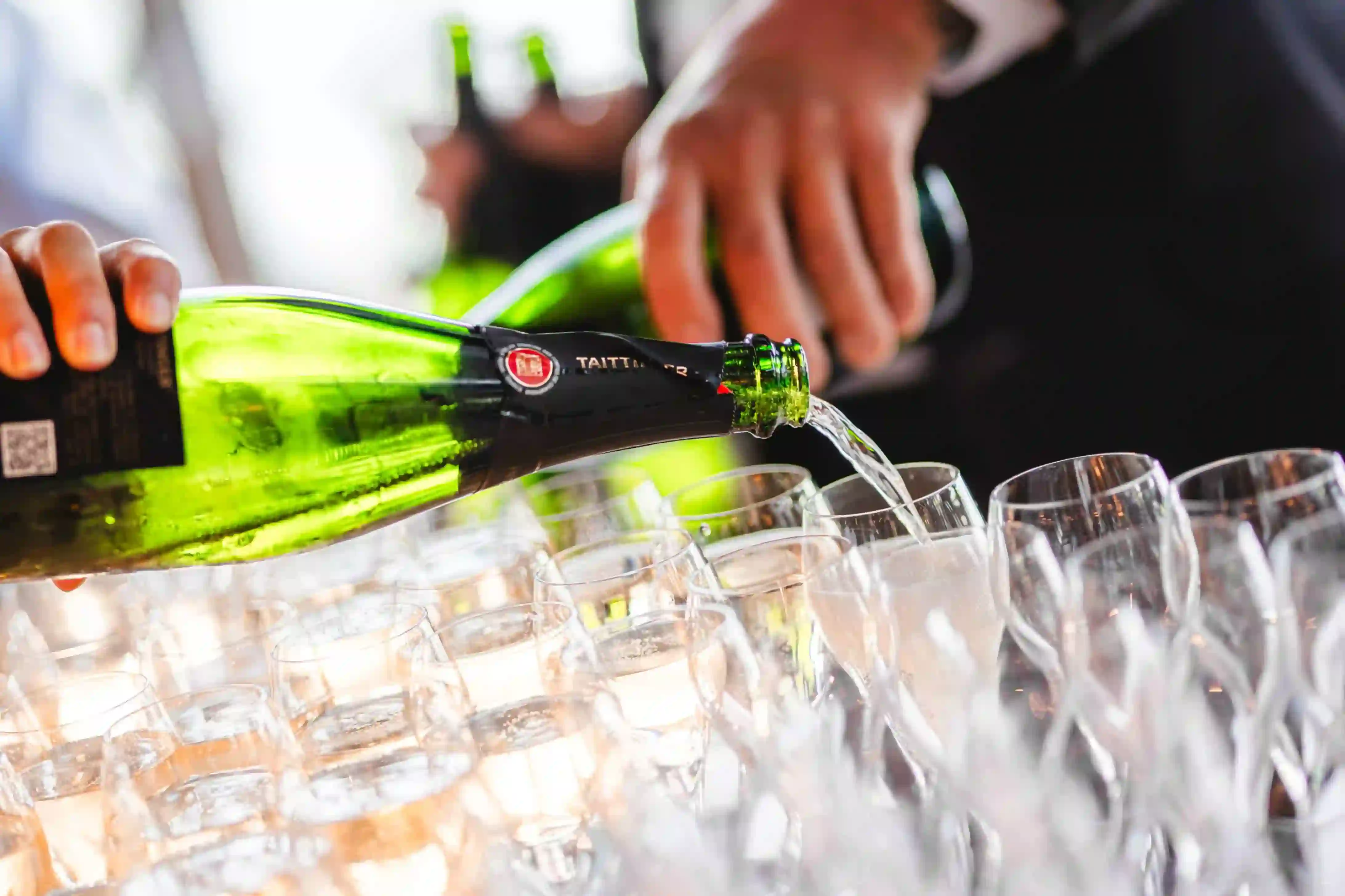 A man spilling champagne in glasses.