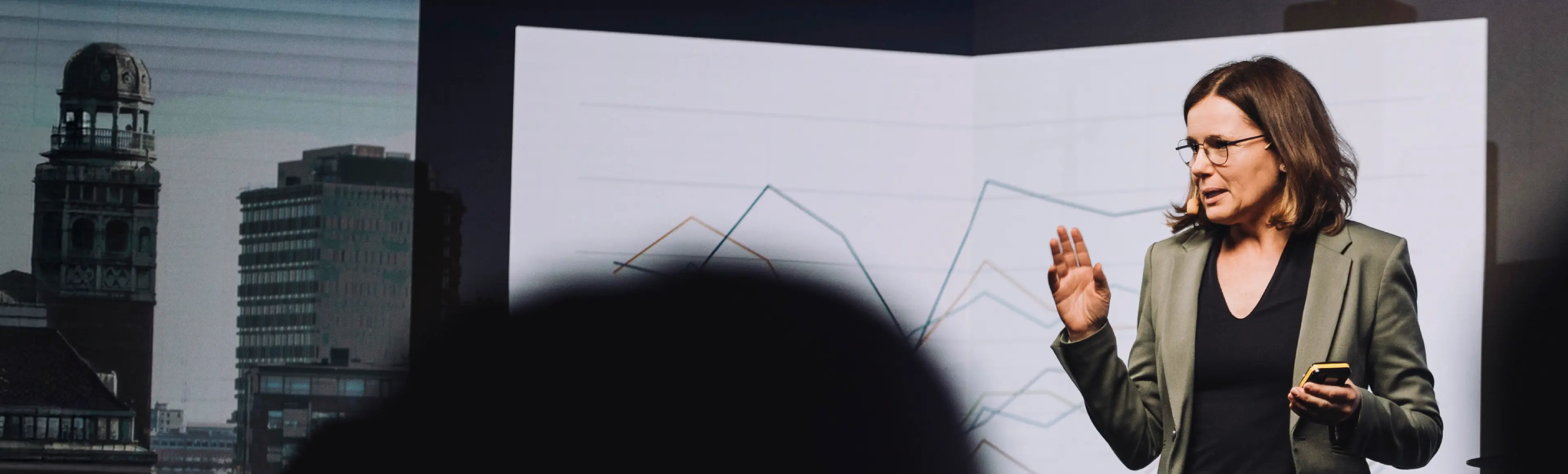 Speaker presenting business insights with performance charts at a TP industry event.