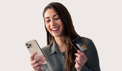 Person holding a smartphone and a credit card, appearing to make an online purchase.