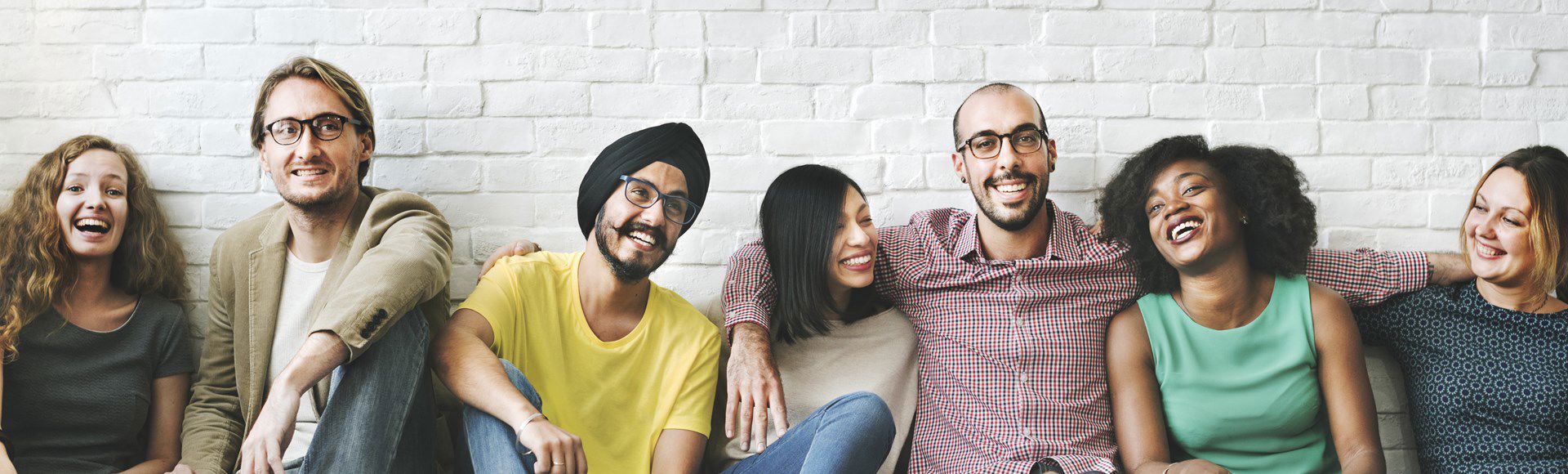Diverse group of coworkers seated in a row, representing collaboration and teamwork.