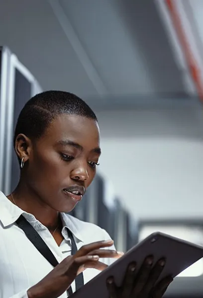 Woman using a tablet to access digital information in a modern workplace.