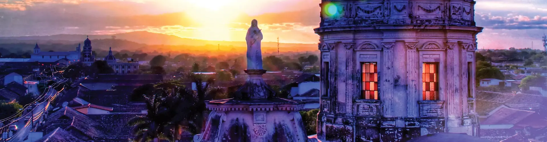 Granada cityscape at sunset with historic architecture and surrounding mountains.