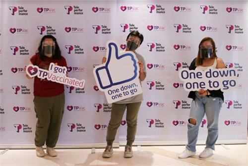 TP employees pose with vaccination signs at a TPVac event.