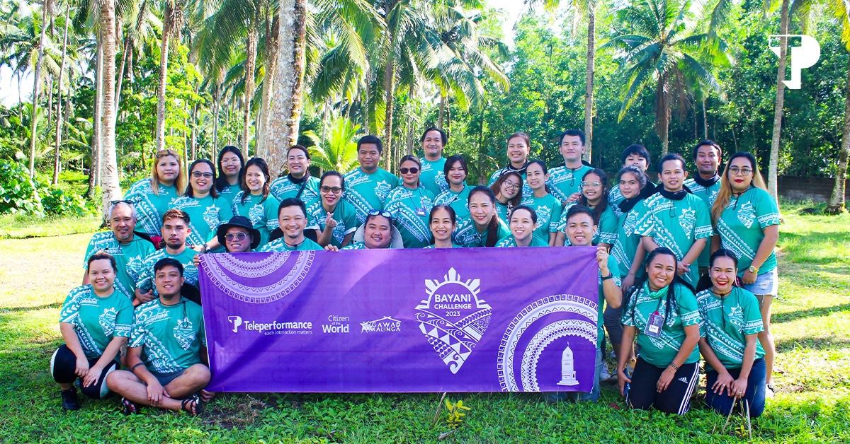 TP employees in green shirts holding a banner at the Bayani Challenge 2023 outdoor event."