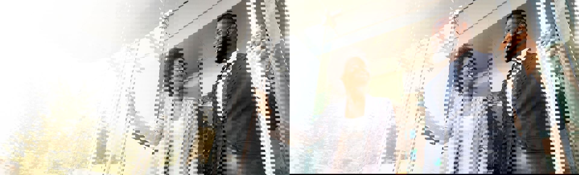 African business couple opening a bright glass door, symbolizing the start of new business opportunities, challenges, and paths to success.