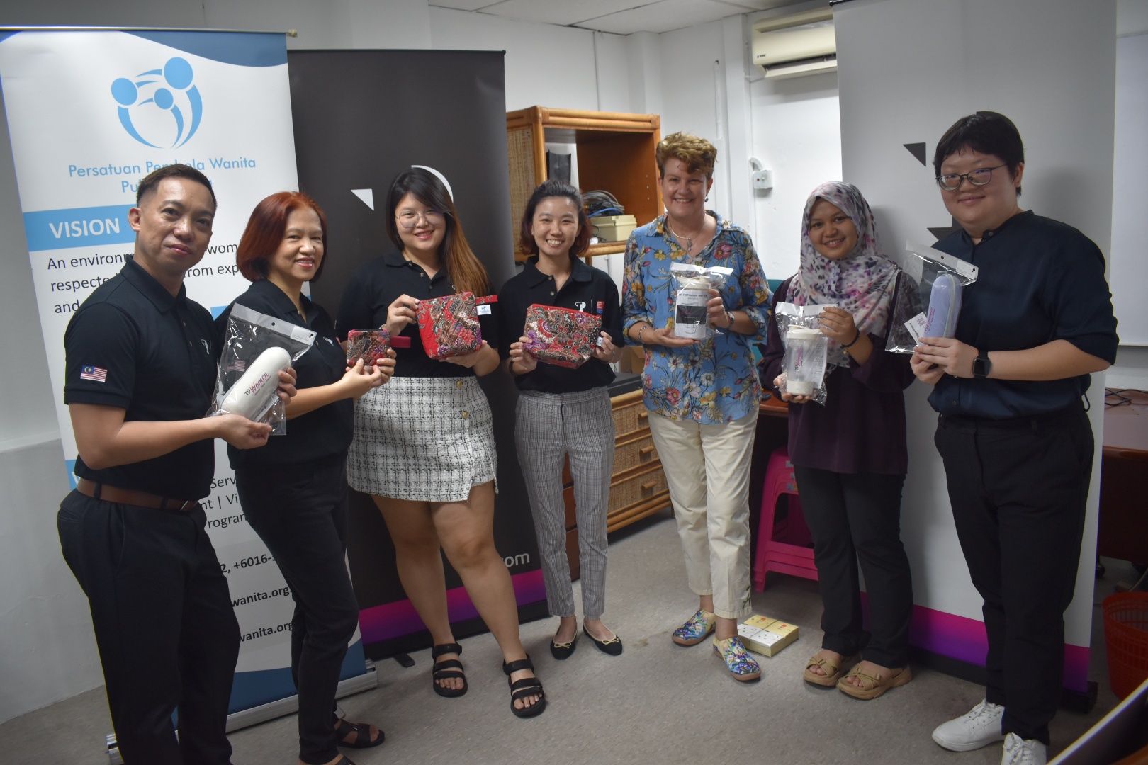 TP employees holding donated items during charity event
