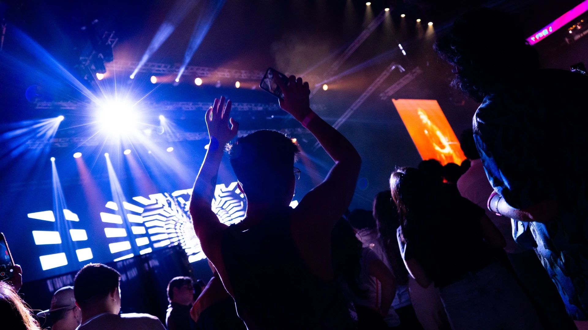 Person with hands up in a nightclub enviroment.
