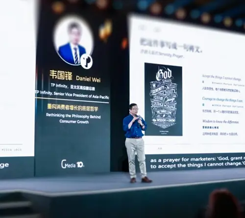 Daniel Wei delivers a keynote speech at a corporate summit on stage.