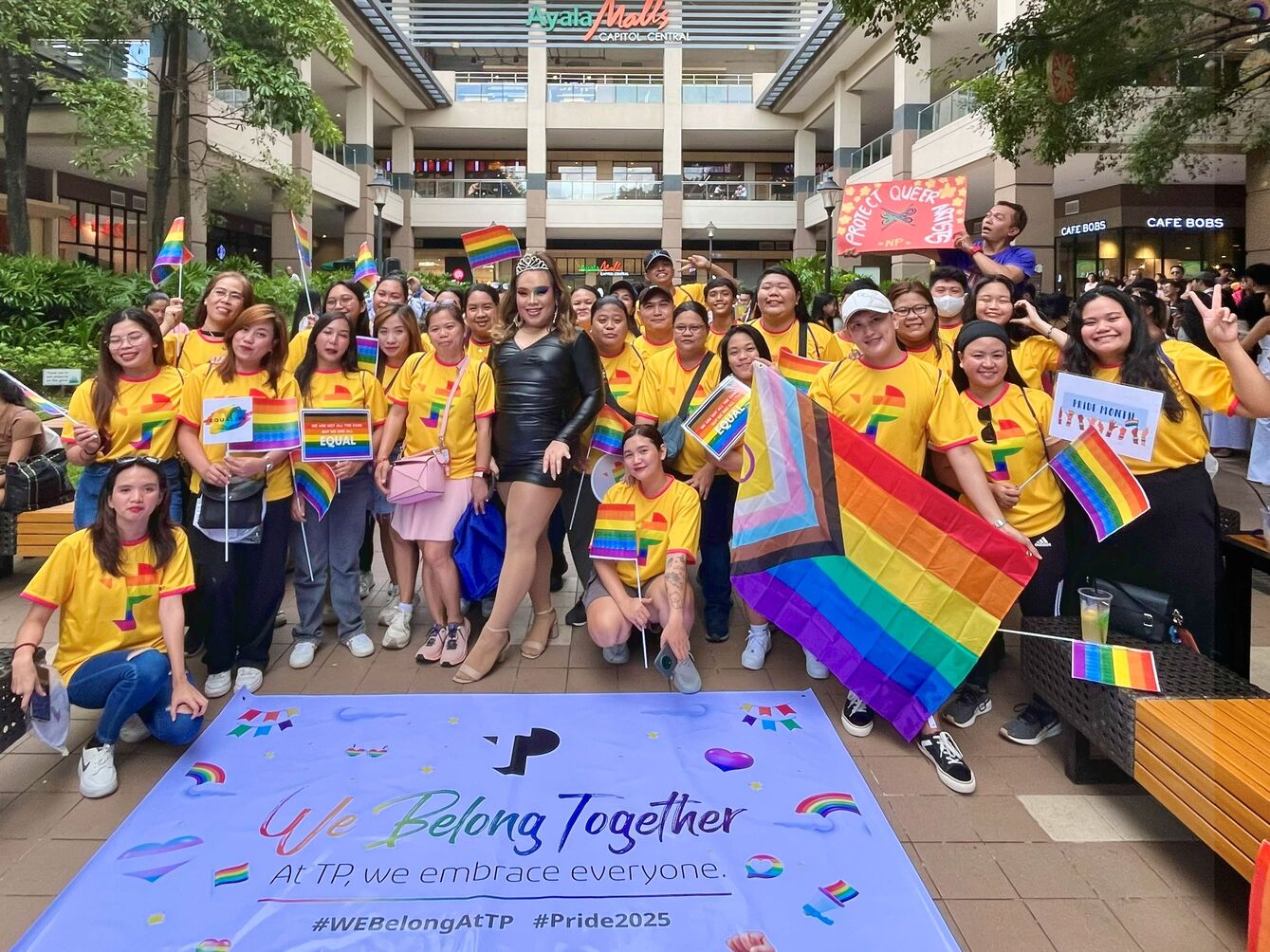 Group of TP employees celebrating Pride with rainbow flags and banners