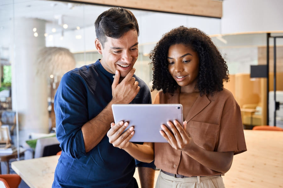 Office colleagues amazed while viewing a tablet, illustrating an insurance white paper.
