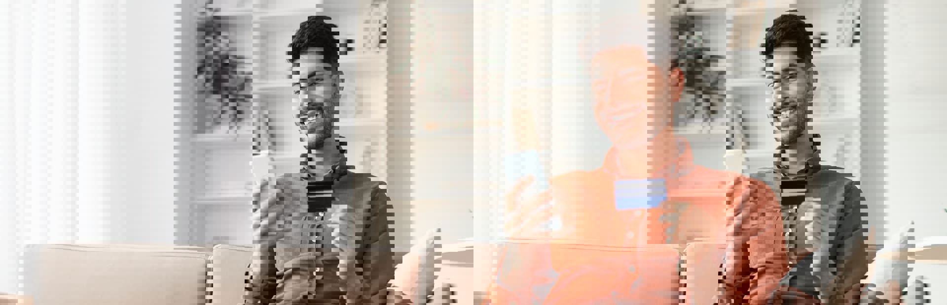 A man holding a credit card and smartphone, illustrating debt recovery services.