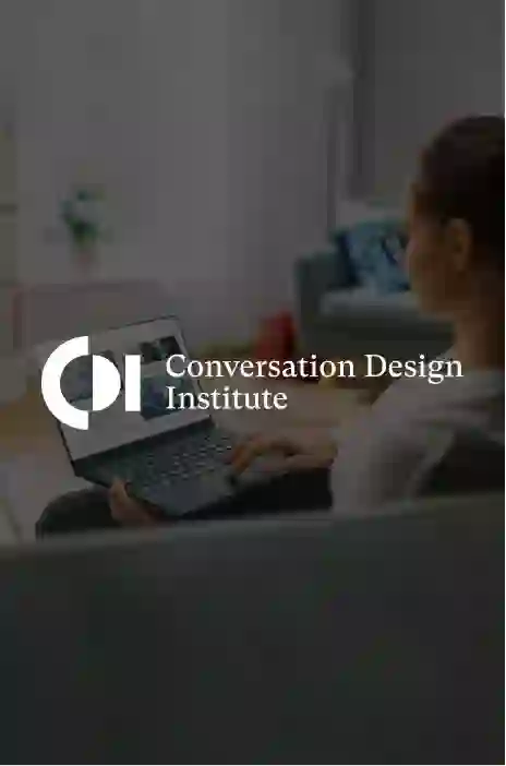 Conversation Design Institute logo in focus with a woman browsing a laptop on the background