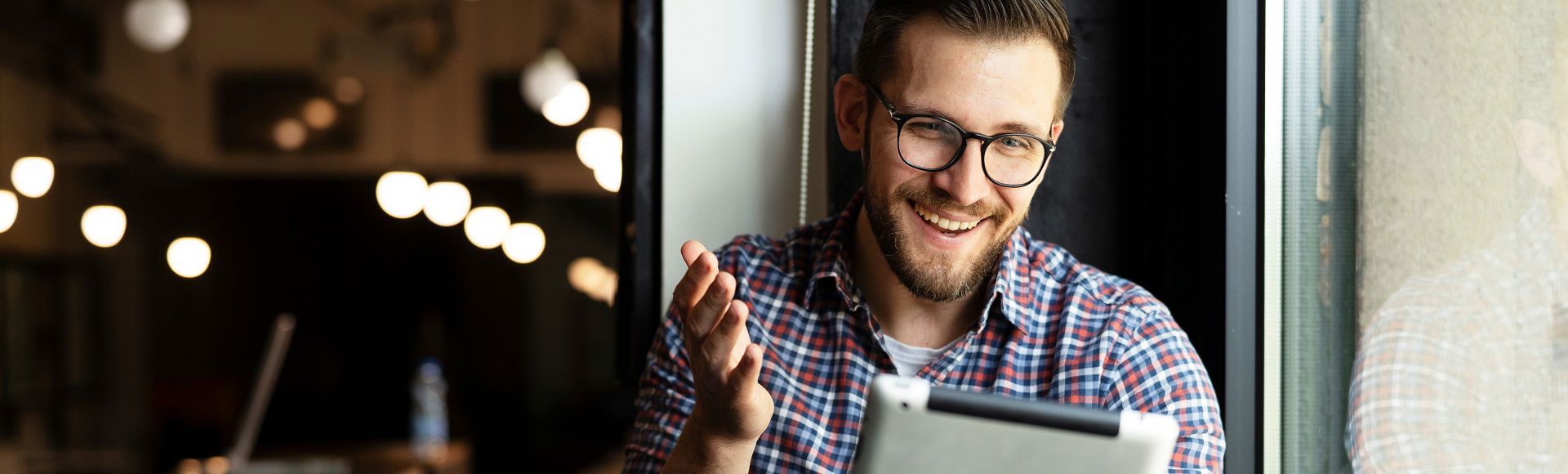 A man smiling while looking at a tablet