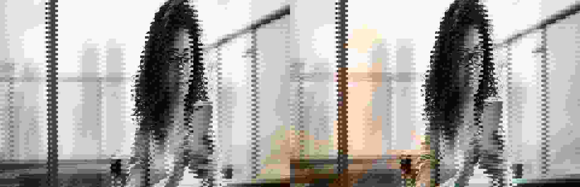 business woman using her cell phone inside a modern glass walls office