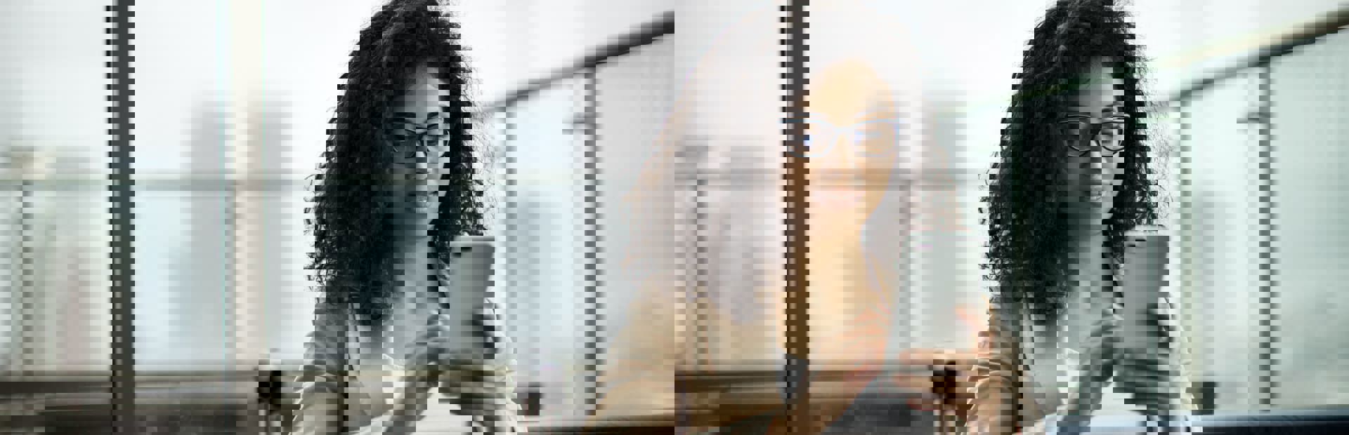 business woman using her cell phone inside a modern glass walls office