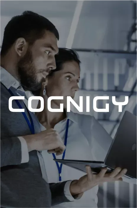 Cognigy logo in focus with two people working in a data center in the background
