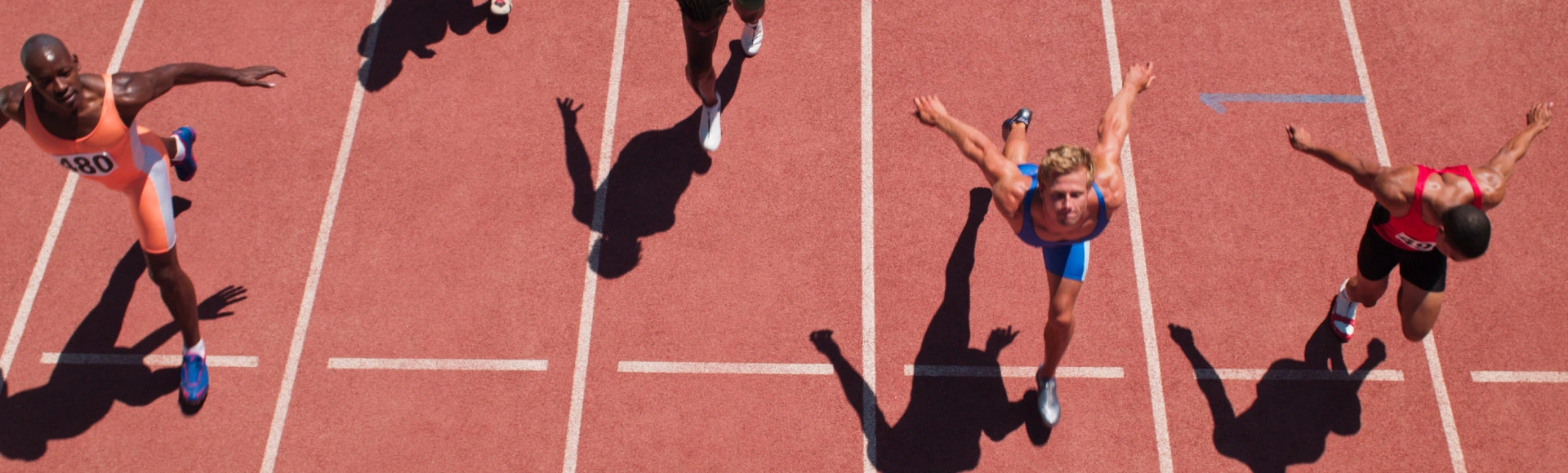Athletes sprinting toward the finish line on a track during a race.