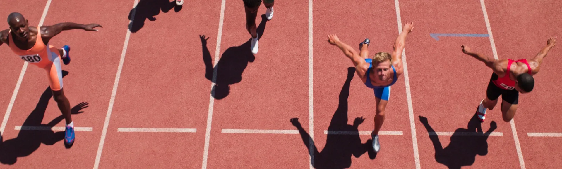Athletes sprinting toward the finish line on a track during a race.
